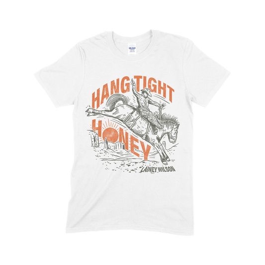 White t-shirt with a rodeo-themed graphic design featuring the text ’Hang Tight Honey’ and an illustration of a bucking horse and rider.