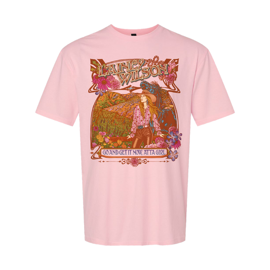 A soft pink cotton t-shirt featuring a vibrant, ornate graphic of lainey wilson with floral and mountain scenery in earthy tones.