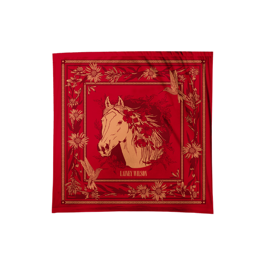 Red silk scarf featuring a gold-embossed horse head surrounded by floral and bird motifs, with ’laney wilson’ printed below.