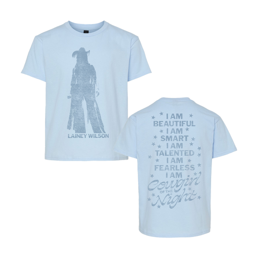 Light blue cotton i am cowgirl of the night youth t-shirt with cowboy silhouette front and silver glitter text back from lainey wilson uk merch