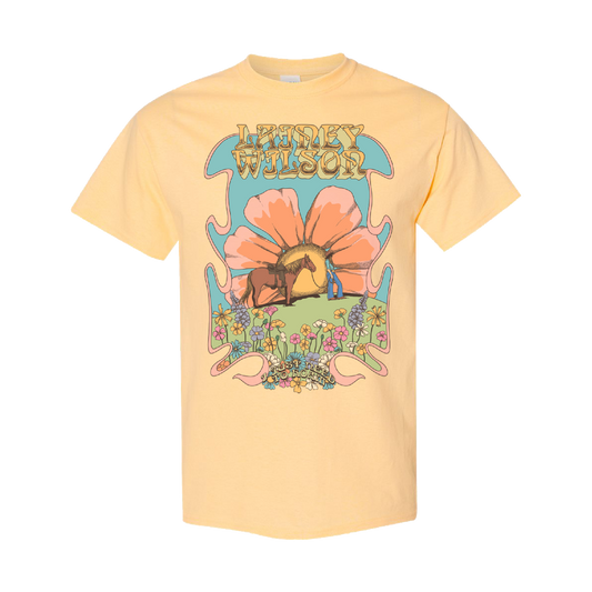 A pale yellow short-sleeved t-shirt featuring a psychedelic graphic of a horse under an orange flower with the text ’lainey wilson’ above it.