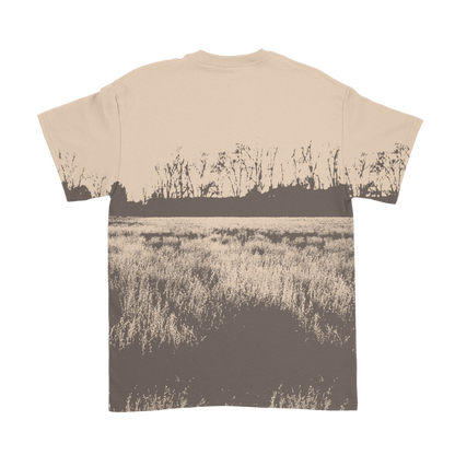 Beige t-shirt featuring a sepia-toned print of a field with tall grass and bare trees in the distance.