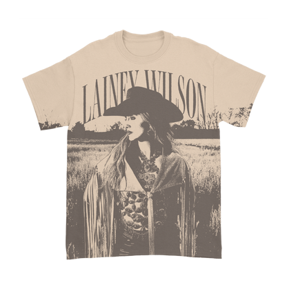 Cream-colored cotton t-shirt featuring a sepia-toned graphic of lainey wilson in a wide-brimmed hat and fringe jacket.
