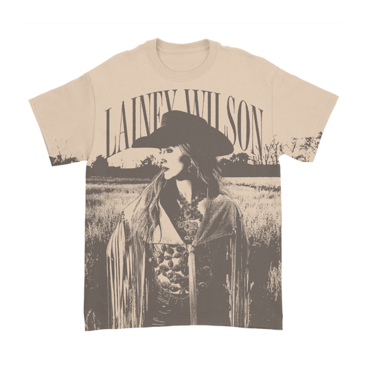 Cream-colored cotton t-shirt featuring a sepia-toned graphic of lainey wilson in a wide-brimmed hat and fringe jacket.