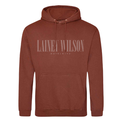 A rust-colored cotton hoodie featuring a front pocket and drawstrings with ’lainey wilson’ printed across the chest in matching tone.