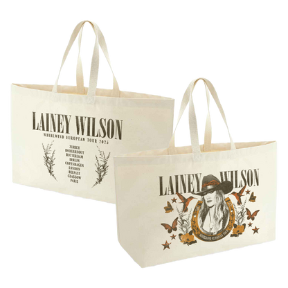 Cream-colored canvas tote bags featuring lainey wilson’s ’whirlwind european tour 2023’’ branding with a graphic of her in a hat surrounded by butterflies and stars.