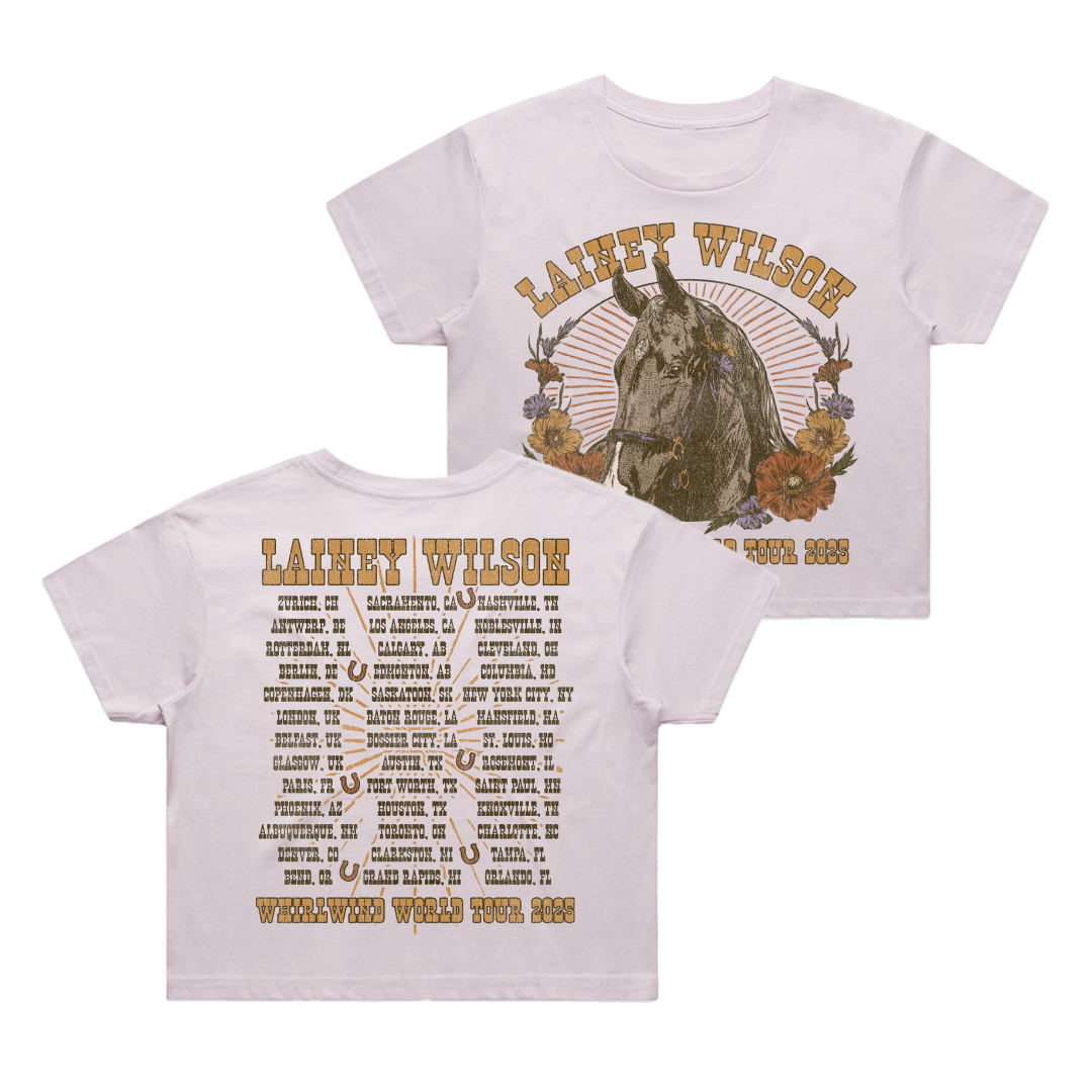 White cropped t-shirt featuring a detailed illustration of a horse surrounded by flowers on the front and an extensive tour itinerary printed across the back.
