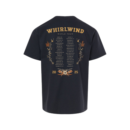 Dark navy blue t-shirt featuring a detailed gold foil print of the ’whirlwind world tour’ itinerary with floral and butterfly embellishments.